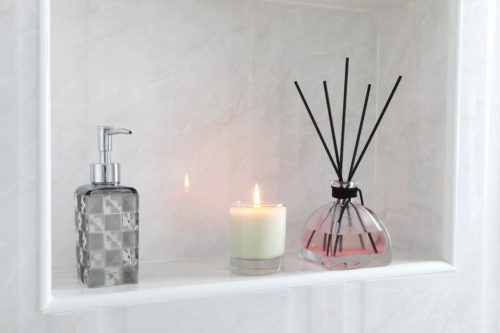 Candle lit and pink diffuser with black rods.