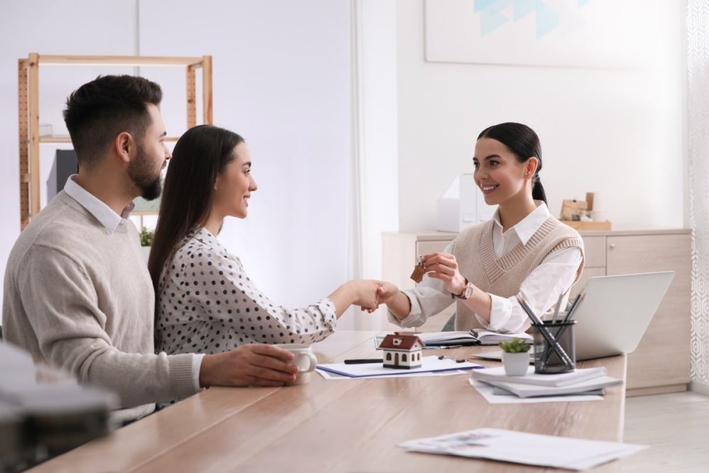 A couple sitting with a property manager as they secure their rental property.