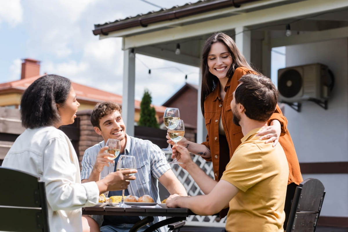 Friends enjoying drinks and a meal outdoors at a home in Brabham.