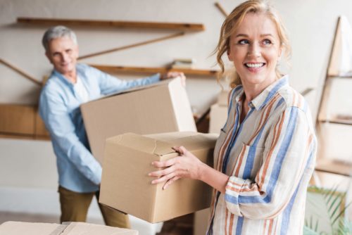 Older couple who are packing boxes to leave their sold property.