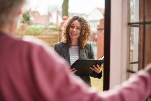 Property manager at a front door discussing landlord responsibilities for maintenance and repairs.