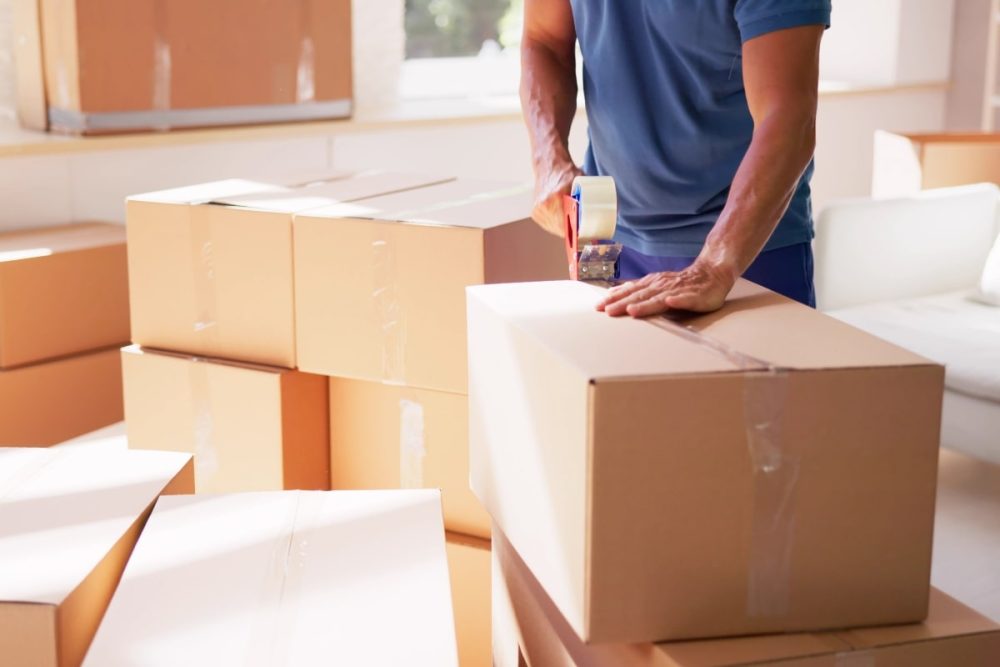 Image of a professional mover, packing belongings in a box.