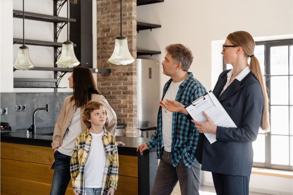 Real estate agent showing a house to a young family.