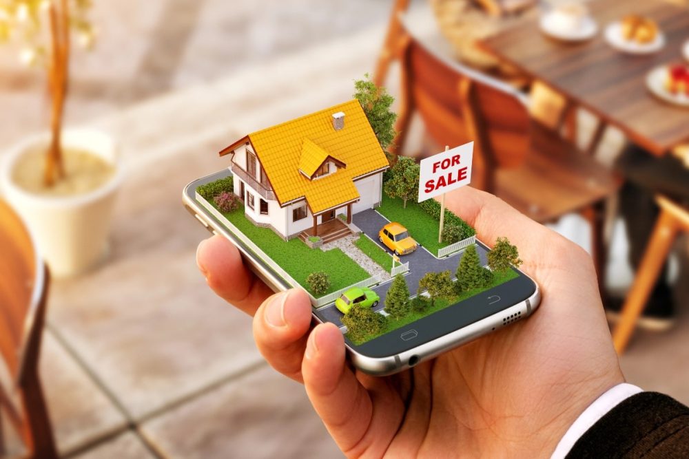 A digital real estate concept showing a house for sale emerging from a smartphone, representing online property listings.