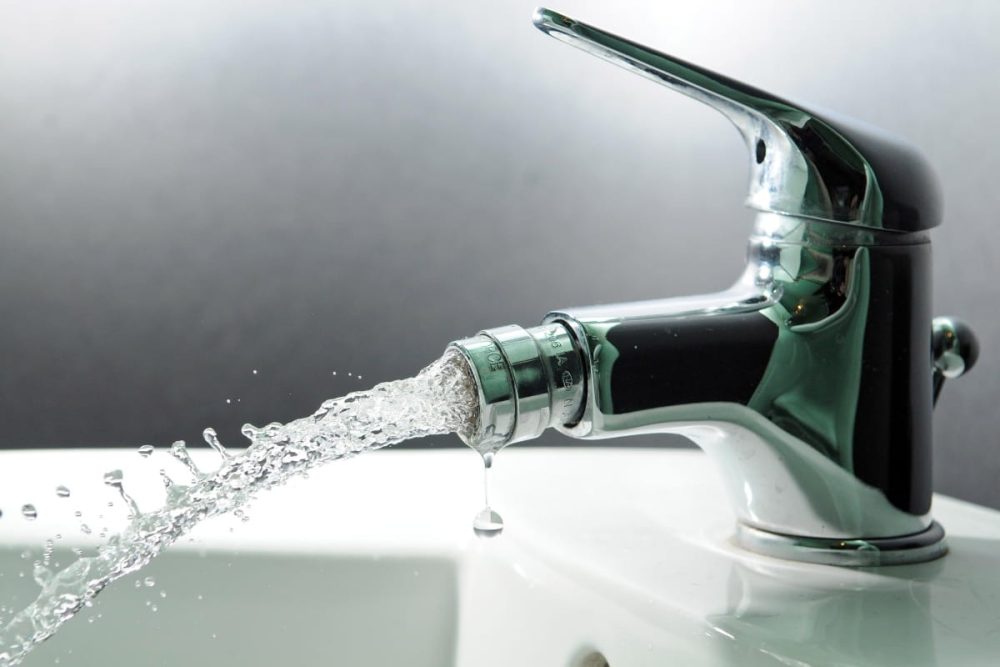 Running tap in a rental property bathroom.