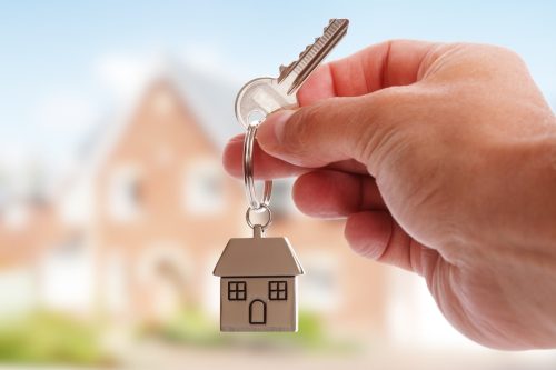 Close up of a hand holding a key, illustrating the idea of what to look for when renting a house.