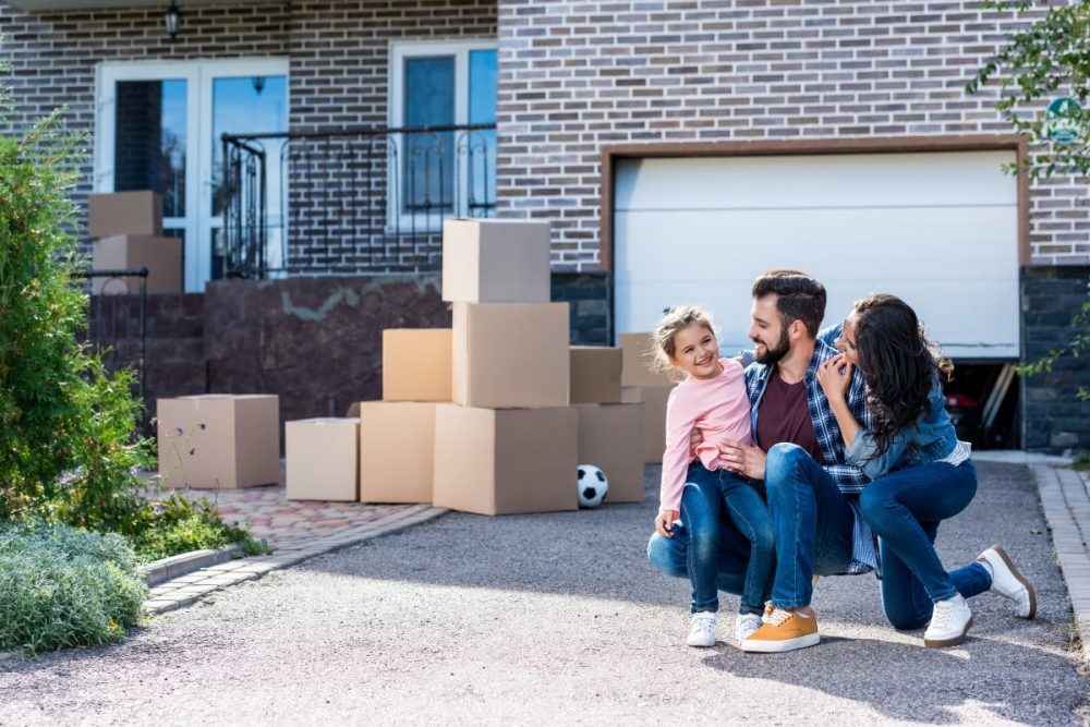 A young family outside a Perth property with moving in boxes.